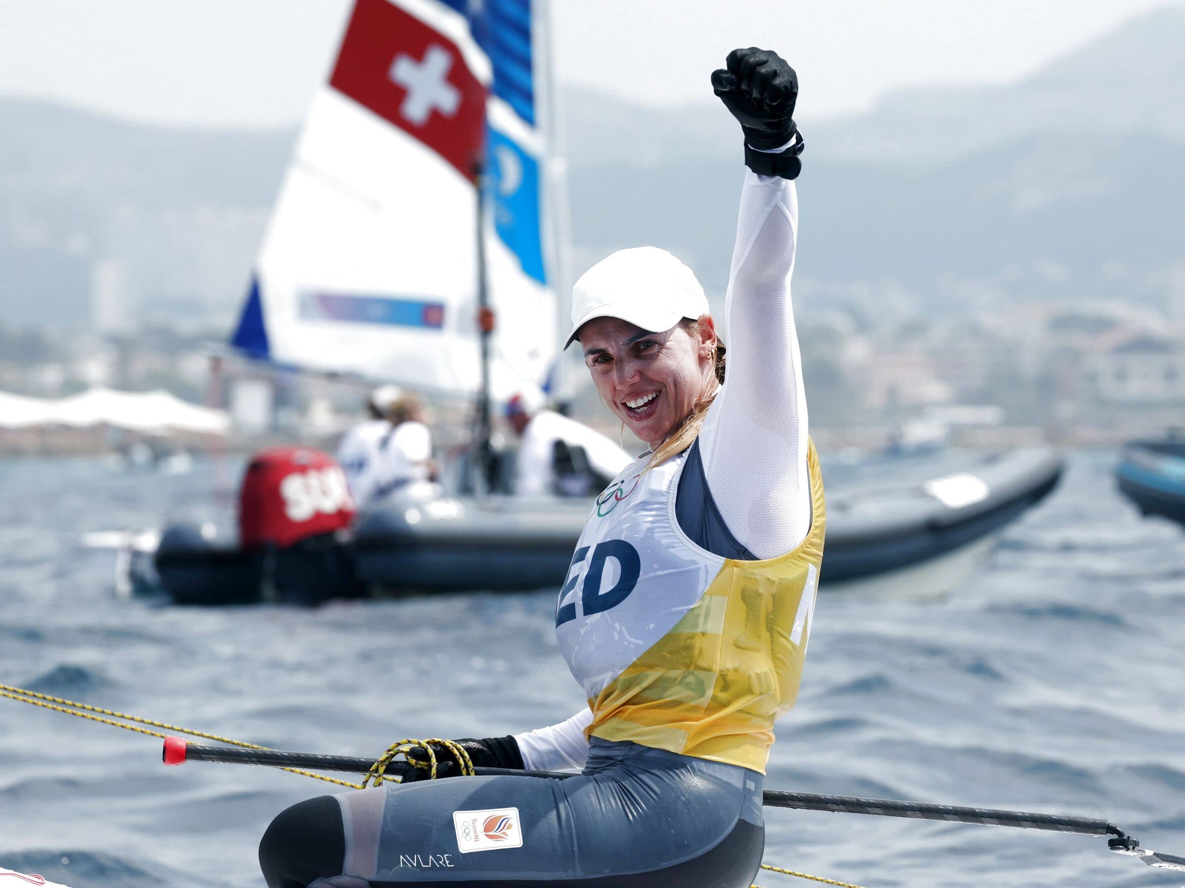 Marit bouwmeester juicht vanaf haar zeilboot nadat ze heeft gewonnen op de olympische spelen