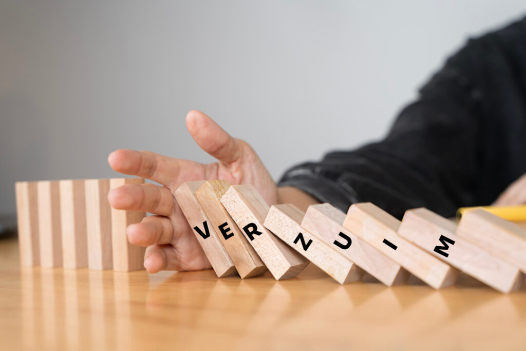 Hand die domino steentjes weerhoudt van vallen. Op de dominostenen staat het woord 'verzuim'