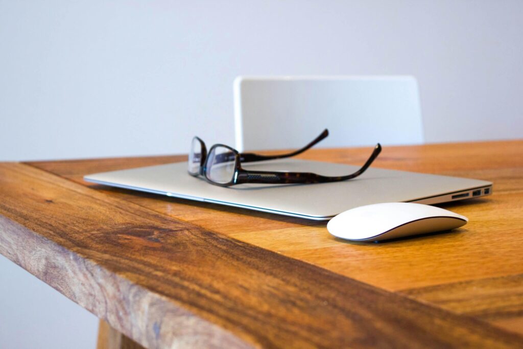 Een leeg bureau van een medewerker die afwezig is met daarop de laptop en de leesbril