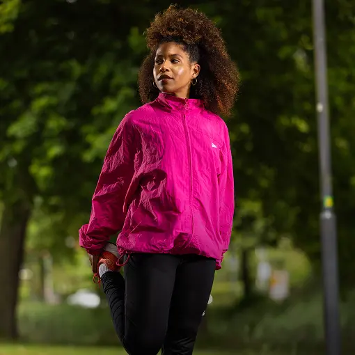 Dame met krullend haar die rekoefeningen doet voor het hardlopen